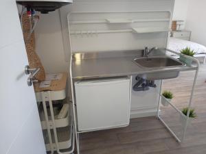 a small kitchen with a sink and a refrigerator at Mata Beach Caparica in Costa da Caparica