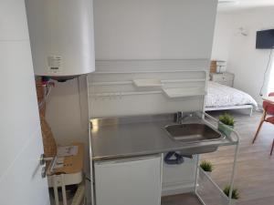 a kitchen with a sink and a bed in a room at Mata Beach Caparica in Costa da Caparica