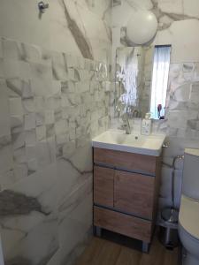 a bathroom with a sink and a toilet and a mirror at Mata Beach Caparica in Costa da Caparica