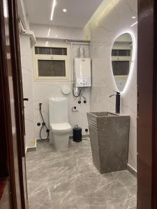 a bathroom with a toilet and a sink and a mirror at 3BR Super Lux Apartment Mohandeseen Perfect for Families in Cairo +24 photos