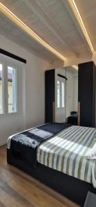 a bedroom with a large bed in a room with windows at Orelli House in Lissone