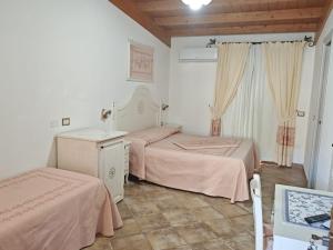 um quarto com 2 camas e lençóis cor-de-rosa em Hotel Barbagia em Dorgali