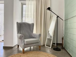 a living room with a chair and a lamp at Central, spacious and bright 2-bedroom apartment By Estio Comfort Living in Heraklio +33 photos