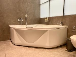 a large bath tub in a bathroom with a toilet at Central, spacious and bright 2-bedroom apartment By Estio Comfort Living in Heraklio