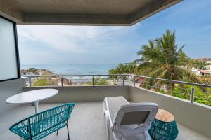 d'un balcon avec une table et des chaises et une vue sur l'océan. dans l'établissement Ancora Punta Mita, à Punta Mita