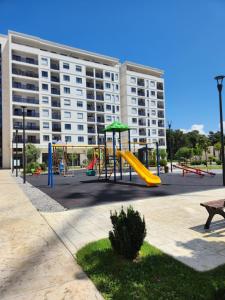 un parque infantil frente a un gran edificio en Green Apartments Podgorica With Garage, en Podgorica