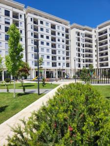 an apartment complex in a park with bushes at Green Apartments Podgorica With Garage in Podgorica