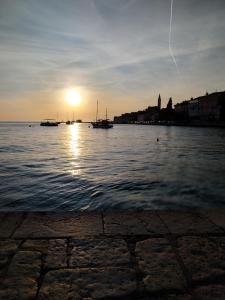 a sunset over a body of water with boats at Dolce Studio Apartmani in Rovinj