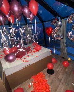 una habitación con una cama con globos y un pastel en Aurora Hut by InukTravel en Nuuk