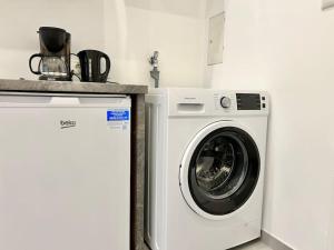 eine weiße Waschmaschine neben einer Theke in der Unterkunft Quiet 60 m2 Apartment with Free Parking in Wien