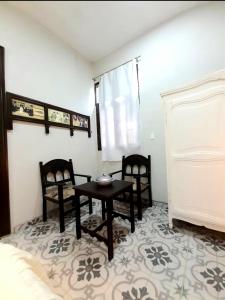 Zimmer mit 2 Stühlen, einem Tisch und einem Bett in der Unterkunft Hotel Boutique Villa Rosarito in Villa del Totoral