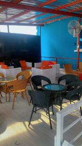 Blue Moon Hotel Victoria Island في لاغوس: مجموعة من الكراسي والطاولات في الغرفة