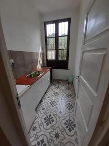eine weiße Küche mit einem Waschbecken und einer Tür in der Unterkunft Hotel Boutique Villa Rosarito in Villa del Totoral