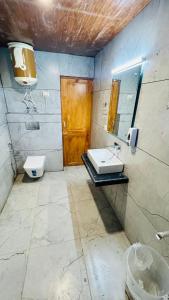 a bathroom with a sink and a toilet and a mirror at Ocean Inn in Manāli