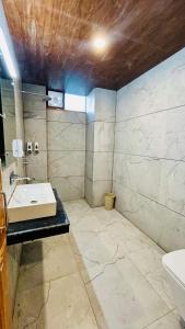 ein Bad mit einem Waschbecken und einem WC in der Unterkunft Ocean Inn in Manali
