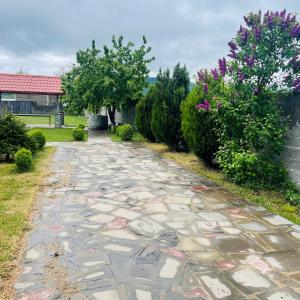 einen Steinweg in einem Garten mit Bäumen und Blumen in der Unterkunft Bazaleti lake home in Bazalet'i