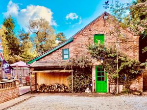 uma velha casa de tijolos com uma porta verde em Squirrel Barn em Milwich