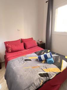 een slaapkamer met een bed met rode kussens en een rood hoofdeinde bij Mira Appartement -Lovely, Tidy & Close to beaches and city center in Al Hoceïma