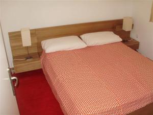 a bedroom with a bed with an orange and white comforter at Mazuran2 in Hvar