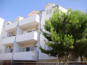 a white building with a tree in front of it at Mazuran2 in Hvar