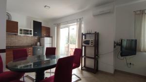 a kitchen with a glass table and red chairs at Mazuran2 in Hvar