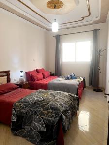 um quarto com 2 camas e uma janela em Mira Appartement -Lovely, Tidy & Close to beaches and city center em Al Hoceïma