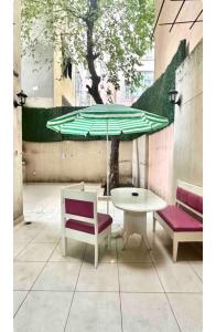 イスタンブールにある3+1 House with garden in the new buildingのテーブル、椅子2脚、緑の傘