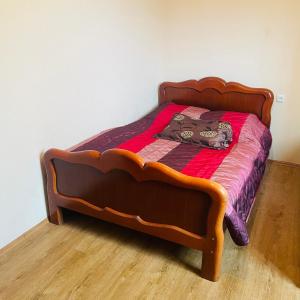 ein Bett mit einem Holzrahmen in einem Zimmer in der Unterkunft Bazaleti lake home in Bazalet'i