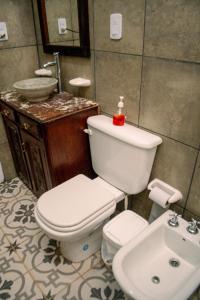 La salle de bains est pourvue de toilettes et d'un lavabo. dans l'établissement Hotel Boutique Villa Rosarito, à Villa del Totoral