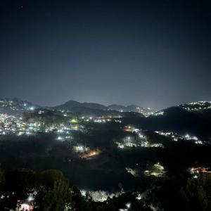 a view of a city lit up at night at Sun Rise View at Twin Oaks' in Kasauli