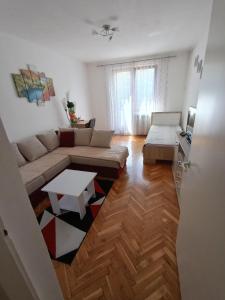ein Wohnzimmer mit einem Sofa und einem Tisch in der Unterkunft Apartman "Plitvice and You" in Plitvička Jezera