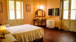 1 dormitorio con cama, mesa y TV en Hotel Boutique Villa Rosarito en Villa del Totoral