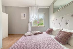a bedroom with a large bed with a pink blanket at Blue Lagoon in Potocnica