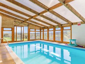 duży basen z drewnianymi sufitami i oknami w obiekcie 3 Bed in Launceston 36820 w mieście Linkinhorne
