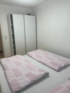 um quarto com uma cama com lençóis cor-de-rosa e brancos em 4 Zimmer Ferienwohnung am Bodensee em Friedrichshafen