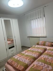 um quarto com uma cama e um espelho em 4 Zimmer Ferienwohnung am Bodensee em Friedrichshafen