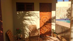 a door to a house with a chair next to it at Residência Brisa mar 2 in Aracati