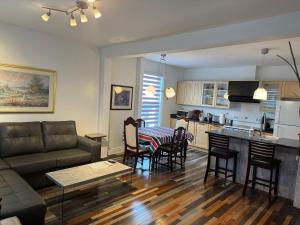 ein Wohnzimmer und eine Küche mit Sofa und Tisch in der Unterkunft Le 2316 in Saint-Hyacinthe