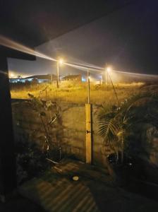 una vista de un campo por la noche con luces de la calle en Cantinho do Manolo en Laguna