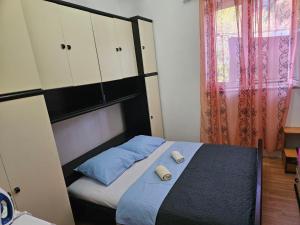 a bedroom with a bed with white and blue pillows at Apartment K&M in Senj