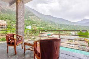 balcón con mesa, sillas y vistas en Vivaan stays en Shamshi