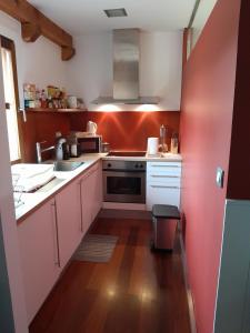 una cocina con armarios blancos y una pared rosa en CASA RURAL AINGERU NATURALEZA Y MONTAÑA en Oñate