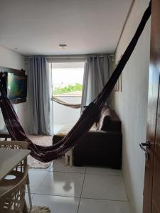 uma rede de descanso num quarto com um sofá e uma janela em Apartamento Villa Giovanne em João Pessoa
