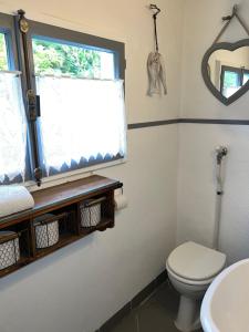 ein Bad mit einem WC und einem Fenster in der Unterkunft Rusticus1706 in Lavertezzo