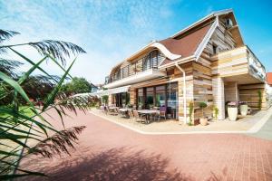 een huis met een patio met tafels en stoelen bij Pensjonat U Jacka in Olsztyn