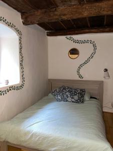 1 dormitorio con cama con almohada y ventana en Rusticus1706, en Lavertezzo