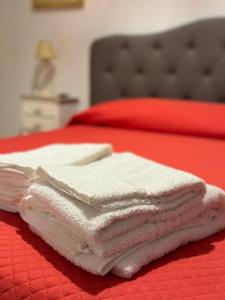 una pila de toallas sentadas encima de una cama en Ulivi di Minerva - Boutique Holiday Home - Apartment ZEUS - Ostuni - Fasano - Cisternino, en Montalbano