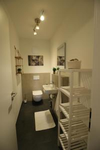 La salle de bains est pourvue de toilettes blanches et d'un lavabo. dans l'établissement Hygge Homes - 3 Zimmer Apartment, barrierefrei mit Terrasse, à Scharmbeck
