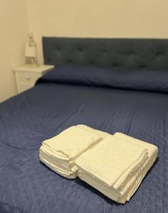 Una cama con dos toallas blancas encima. en Ulivi di Minerva - Boutique Holiday Home - Apartment ZEUS - Ostuni - Fasano - Cisternino, en Montalbano