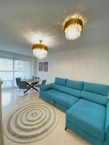 ビリャホヨサにあるApartamento Familiarのリビングルーム(青いソファ、テーブル付)